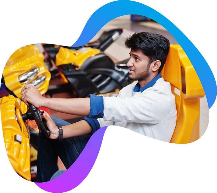 Ein junger Mann spielt Rennspiel in Joystick-Form über gameplaza